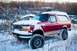 1995 Ford Bronco - A red 1995 Ford Bronco sits partially covered in snow during a winter day.
