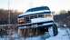 1995 Ford Bronco - This Ford truck is partially covered in snow, with its front end angled towards the viewer in a winter landscape.