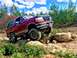 1995 Ford Bronco - This 1995 Ford Bronco is shown tackling a challenging off-road course with large rocks and uneven ground.