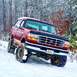1995 Ford Bronco - A red 1995 Ford Bronco navigates a snowy, wooded trail.
