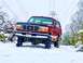 1995 Ford Bronco - This red 1995 Ford Bronco is navigating a snowy landscape, its off-road capabilities.
