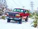 1995 Ford Bronco - This red Ford Bronco is parked in a snowy landscape with power line towers visible.