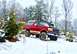 1995 Ford Bronco - A red Ford Bronco navigates a snow-covered forest road.