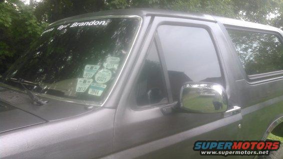 Dark gray Ford Bronco driver's side, windshield with stickers.