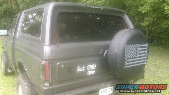Dark gray SUV with a spare tire cover featuring a wrench American flag design.