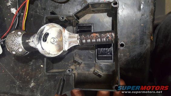 Gear shifter assembly with chrome knob and black lever, inside a black plastic housing