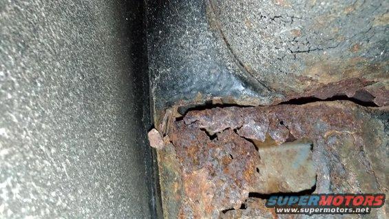 Heavily rusted frame rail with visible Supermotors.net watermark