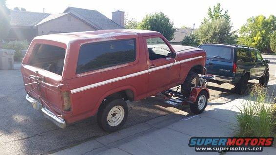 Red 1981 Ford Bronco on a trailer, side view