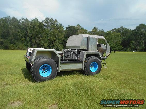 Custom all-terrain vehicle with large blue-rimmed tires and exposed engine cooling fans