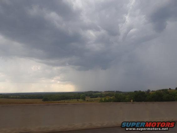 Stormy sky with rain falling over a rural landscape