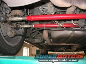 Red suspension components and exhaust system visible on the underbody of a vehicle