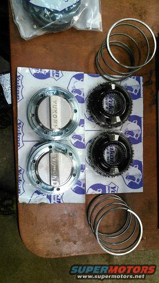 Two Yukon locking hubs and two gear sets with rings on a wooden surface