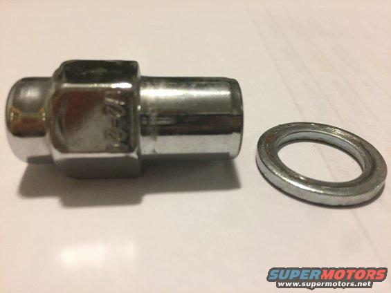 Chrome lug nut with markings and a metal washer on a white surface