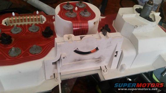 Dashboard instrument cluster with red circuit board and white housing