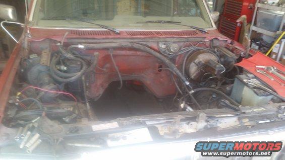 1985 Ford Bronco engine bay with engine removed, showing brake booster and firewall
