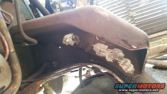 Rusty vehicle frame with visible metal patches and wiring