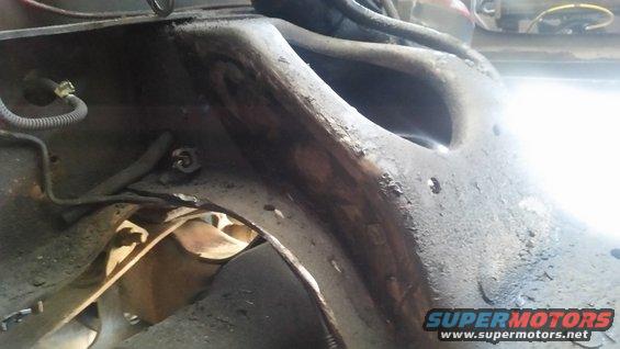 Close-up of heavily rusted metal frame component with wires attached