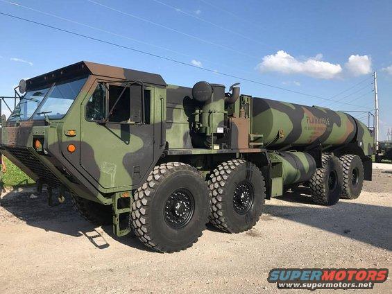 Camouflaged military fuel truck with large off-road tires