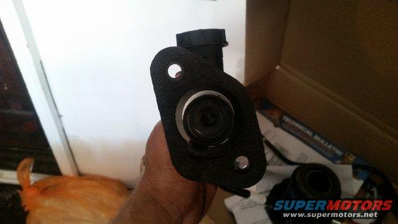 hand holding clutch master cylinder assembly, box with technical bulletin in background