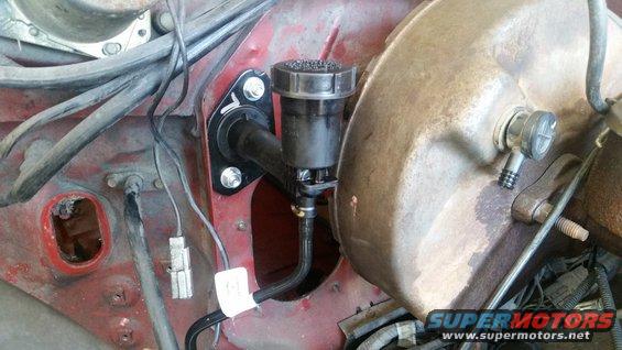 Brake master cylinder reservoir and booster assembly in engine bay