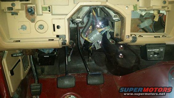 1985 Ford Bronco interior showing dashboard wiring and pedals. Rear defrost switch visible
