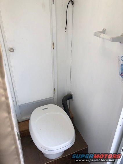 Interior of a small bathroom with a toilet and a door