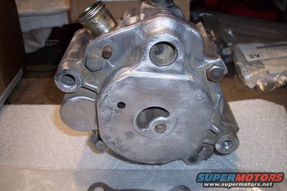 Aluminum power steering pump with metal fittings and bolt heads visible