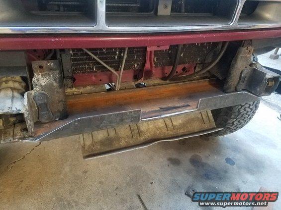 Front bumper being modified with new metal plates. Radiator and frame visible