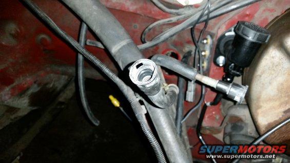 Engine bay with hoses, wires, and a brake fluid reservoir