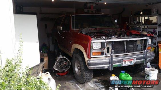 1985 Ford Bronco front view, hood open, transmission removed, red exterior
