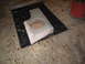 1994 Ford Bronco - A custom-built subwoofer enclosure is prepared for installation, resting on a black tarp on a garage floor.
