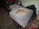 1994 Ford Bronco - Custom subwoofer enclosure, likely for a vehicle interior, covered in gray carpet with a large circular opening.