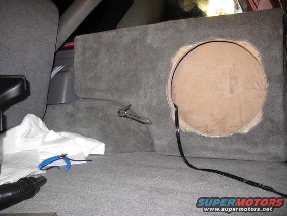 1994 Ford Bronco interior showing a custom subwoofer box being installed behind the rear seat