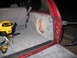 1994 Ford Bronco - Installing a custom subwoofer enclosure in the rear cargo area of an SUV, with tools and a shop vac present.