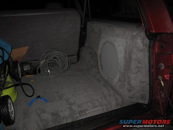Interior cargo area of a 1994 Ford Bronco with a custom subwoofer box installed behind the rear seat