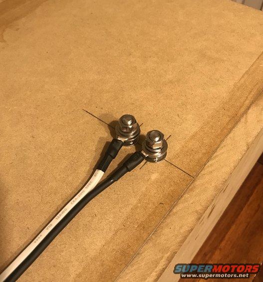 Two battery terminals with V10 10AWG wires on wood