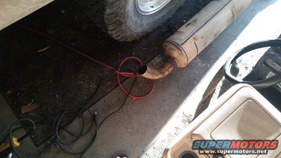 Engine bay with red fluid leak and exposed wiring