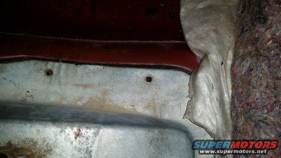 Close-up of interior paneling with insulation and red metal trim