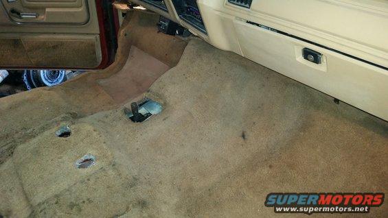 Interior floor and dashboard of a vehicle with carpet removed