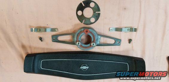 Black steering wheel horn pad with silver trim and Chevrolet logo, plus steering column parts and screws