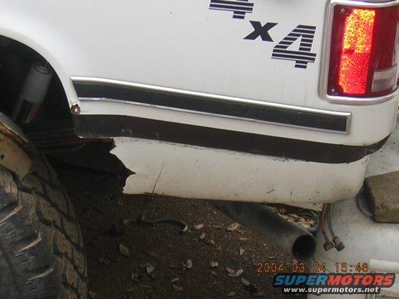 White truck rear quarter panel with 4x4 decal and damaged lower bodywork