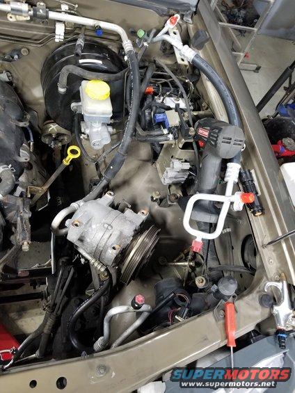 With the compressor flipped, the bottom of the high-pressure hose was visible, showing dye.  So I ordered this replacement.  The refrigerant had already leaked out, so I swapped the hose later during reassembly.