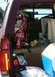 1996 Ford Bronco - The cargo area of a vehicle is filled with various items, including a large red bag and a cooler.