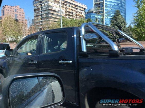Dark blue pickup truck with chrome roll bar, seen from side