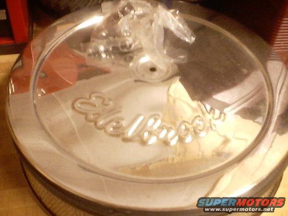 Chrome air cleaner lid with Edelbrock logo, some plastic wrap on top