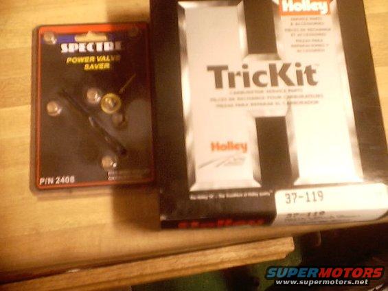 Spectre Power Valve Saver and Holley TrickKit carburetor parts on a wooden surface