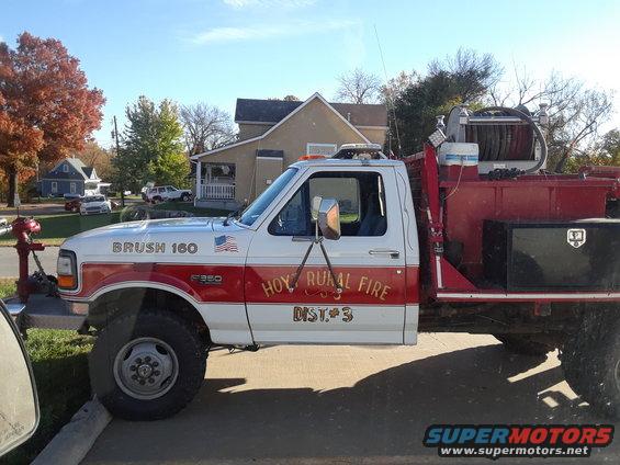 Side view of a white and red Ford F350 fire truck labeled "BRUSH 160" and "HOY RURAL FIRE DIST. 3"
