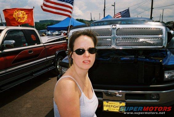 Front view of a blue Dodge Ram truck with a chrome grille and a yellow license plate reading "FIREFIGHTER"