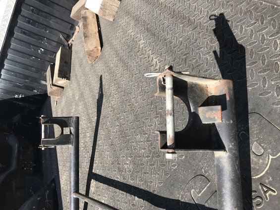 Metal brackets and wooden blocks on a textured truck bed surface