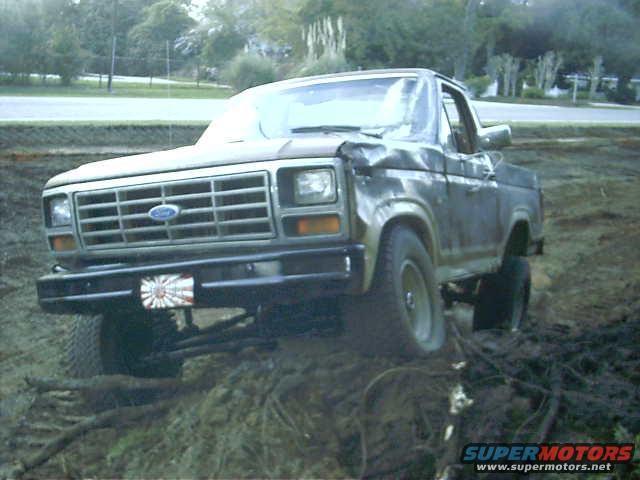 Damaged Ford Bronco in mud, 3q-front view